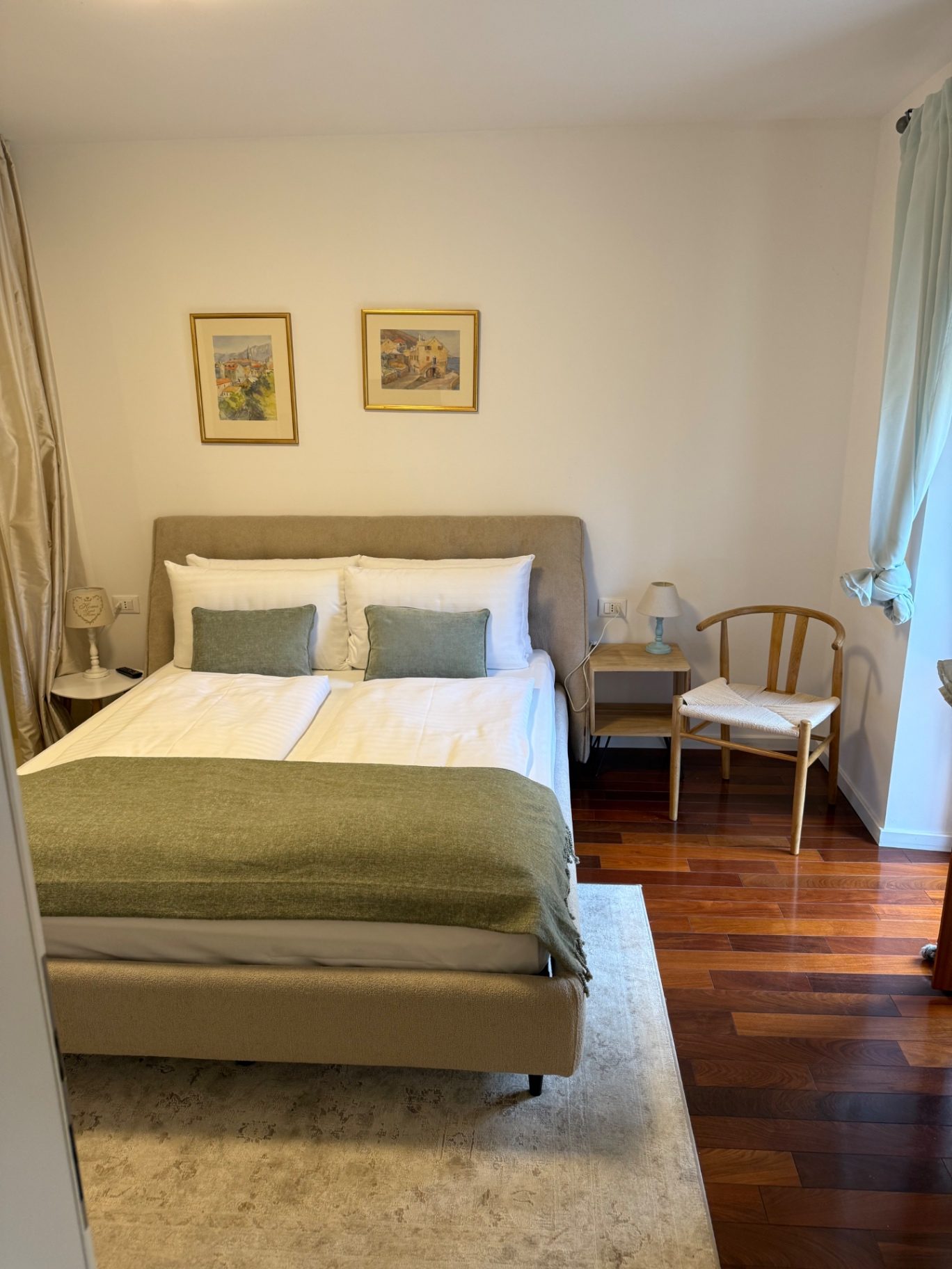 Guest room with green throw and parquet floor